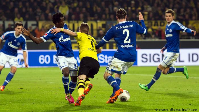 Players tackling the ball during a match between Borussia Dortmund - FC Schalke 04, Germany