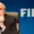 Зепп Блаттер на фоне эмблемы ФИФА