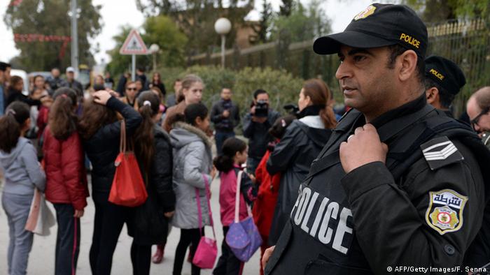 A policeman stands guard as visitors queue up outside Tunisia's Bardo National Museum on March 24, 2015.