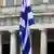 Греческий флаг на фоне здания парламента