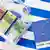 Прозрачный чемоданчик с деньгами на фоне флага Греции и с припиской "С наилучшими пожеланиями" от Евросоюза.