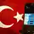 A picture representing a mugshot of the twitter bird is seen on a smart phone with a Turkish flag on March 26, 2014 in Istanbul (photo: OZAN KOSE/AFP/Getty Images)