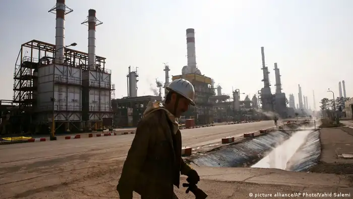 A man walks past an oil refinery in the south of the Iranian capital Tehran