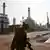 A man walks past an oil refinery in the south of the Iranian capital Tehran