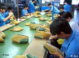 Factory workers make shoes on the production line at a shoe factory in Ningbo, Zhejiang province 12 July 2004. Chinese shoe manufacturers have increased their exports to the European Union by almost 700 per cent since trade restrictions were abolished in January 2005. The dramatic rise was accompanied by a steep fall in prices as Chinese producers recorded massive gains in market share. In some categories, imports of Chinese shoes rose 14-fold while the average price of a pair of shoes from China dropped 28 per cent. +++(c) dpa - Report+++