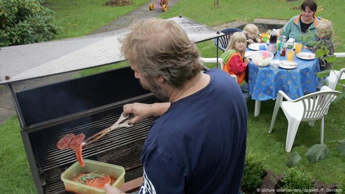 Ein Mann steht am Grill legt ein Stück Fleisch auf den Rost (Foto: picture-alliance/dpa/dpaweb/F. Gentsch)