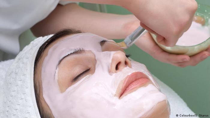 Eine Frau mit Gesichtsmaske bei einer kosmetischen Behandlung