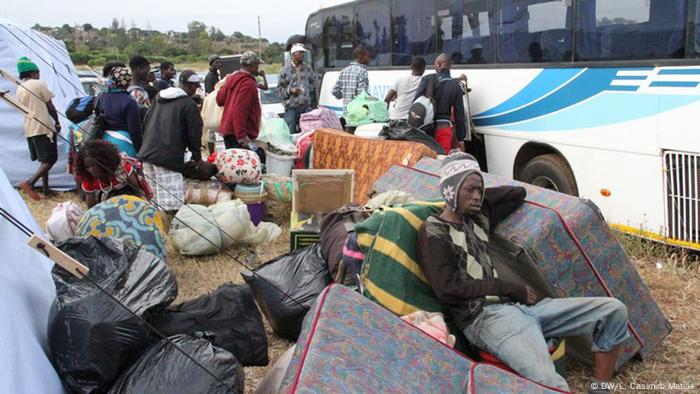 Victims of xenophobia in South Africa wait at a bus stup in Mozambique