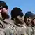 Бородатые мужчины в черных шапках и военной униформе на построении - отряд чеченского спецназа