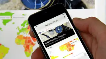 hand holds mobile phone showing Media Freedom Navigator application 