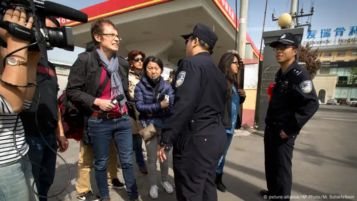 Ein Kamerateam wird von chinesischen Polizisten bedroht. (Foto: picture-alliance/AP Photo/M. Schiefelbein)