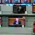 Ребенок смотрит на телевизоры в магазине, на экране которых выступление Лукашенко