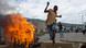 Demonstrant springt über eine brennende Barrikade in Bujumbura (Foto: Phil Moore/AFP/Getty Images). Demonstrant springt über eine brennende Barrikade in Bujumbura (Foto: Phil Moore/AFP/Getty Images).