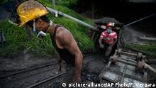 Miners leave the tunnel after their shift at La Flauta coal mine in Tausa, Colombia, Tuesday, Sept. 24, 2013. Tausa residents fear that La Flauta will be closed if authorities declare the area a nature reserve in which mining is prohibited. (AP Photo/Fernando Vergara)