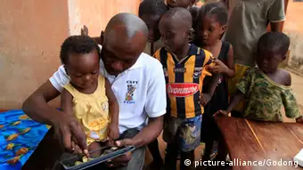 African children playing with a tablet computer.