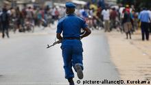 19.05.2015 epa04756945 A Burundian police officer rushes to control the protesters during an anti-government demonstrations in Bujumbura, Burundi, 19 May 2015. Protesters defied the government warnings by continuing the street protests in the capital on 19 May. Regional leaders have called Burundi's President Pierre Nkurunziza, who had returned to the country after a failed coup, to postpone the country's parliamentary and presidential elections scheduled for 26 May and 26 June respectively. According to the United Nations' refugee agency, more than 105,000 Burndians have fled the country to seek refuge in neighbouring countries such as Rwanda, DR Congo, and Tanzania. EPA/DAI KUROKAWA