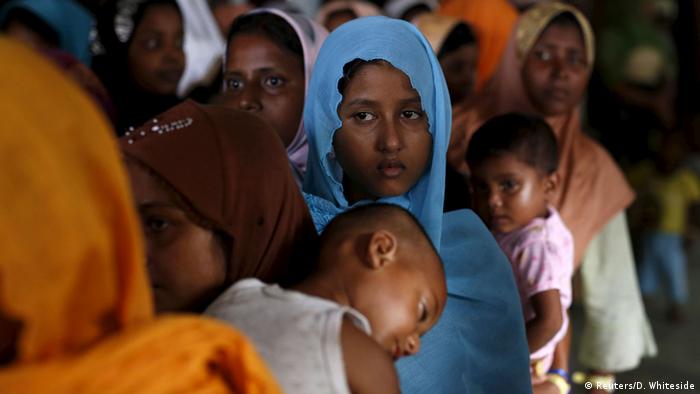 Ethnic Rohingya Muslim women wait to recieve donations