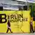 Arbeiter hantieren am in Berlin an einem Plakat mit der Aufschrift 'Erst Berlin dann Borsigplatz' von Borussia Dortmund (Foto: dpa)