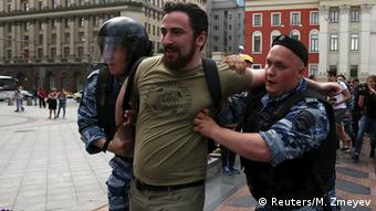 man being held by two policemen copyright: REUTERS/Maxim Zmeyev
