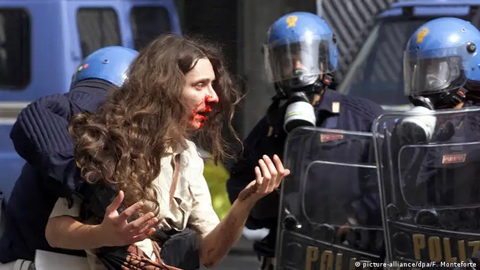 Bleeding protester being led away by police at the G8 Summit in Genoa in 2001 (picture-alliance/dpa/F. Monteforte)