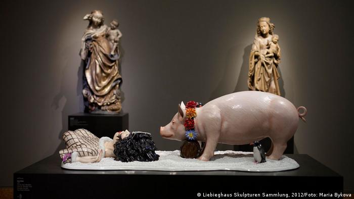 Jeff Koons, Fait d'hiver, scuplture with pig and female torso, two sculptures of Mary and Jesus in the background