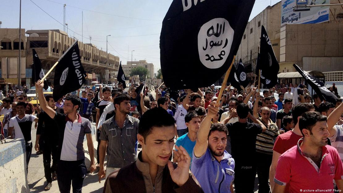 IŞİD, 2014'te Musul'un kontrolünü ele geçirmişti. Kentte IŞİD bayrağıyla yürüyen erkekler görülüyor.