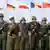 bandeiras dos países do Pacto de Varsóvia com soldados à frente 