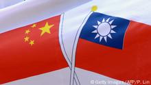 A pro-independence protester holds a banner printed with the national flags of Taiwan and China to satirize the closer Taipei-Beijing economic ties, during a demonstration against the visit of China's chief Taiwan negotiator Chen Yunlin outside the airport in the central Taiwanese city of Taichung on December 21, 2009. Chen Yunlin flew into the island amid a push by Taipei for a sweeping trade pact with its giant neighbour in the face of vehement opposition protests. AFP PHOTO / PATRICK LIN (Photo credit should read PATRICK LIN/AFP/Getty Images)