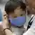 Ein Vater am Flughafen Incheon in Südkorea befestigt bei seinem kleinen Sohn eine Atemschutzmaske (Foto: rtr)
