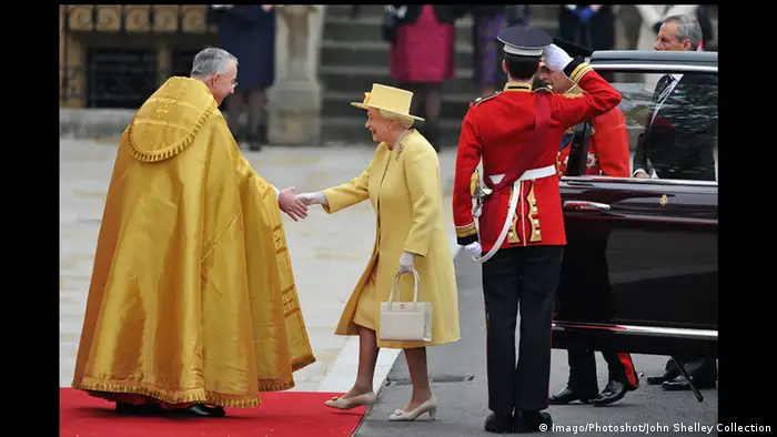 Königin Elisabeth II. in Senfgelb an der Schwelle von Westminster, sie begrüßt den Dekan. Foto: Imago