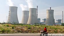 ARCHIV 2014 **** --FILE--A Chinese woman rides her electric bike past a coal-fired power plant in Huaian city, east China's Jiangsu province, 16 May 2014. China's emissions of climate-warming carbon dioxide fell in 2014 for the first time in more than a decade, offering fresh evidence that efforts to control pollution in the nation of 1.4 billion people are gaining traction. Total carbon emissions in the world's second-biggest economy dropped 2 percent in 2014 compared with the previous year, the first drop since 2001, according to a data. In the battle to rein in pollution, China has cut its dependence on coal. The nation, the world's biggest carbon emitter, has also poured money into clean energy sources such as solar, wind and hydro developments.