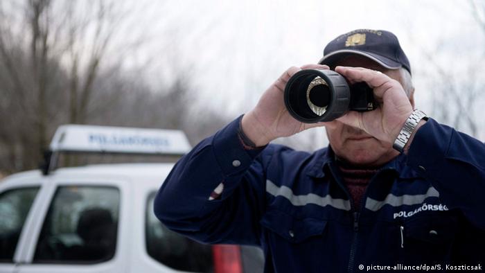 Доброволец-помощник венгерской полиции следит за границей с Сербией.