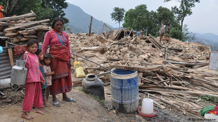 Непальцы перед разрушенным домом