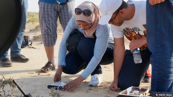 Teilnehmer testen ein Satelitten-gestütztes Modem in Libyens Wüste Foto: DW