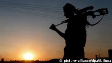 epaselect epa04815702 A member of Kurdish People Defence Units (YPG) guards during a sunset near Tel Abyad border gate, northern Syria, 23 June 2015. Turkey on 22 June opened the border crossing to Tel Abyad, aka Tell Abiad or Tal Abyad, in northern Syria, allowing hundreds of refugees to return home to an area which a Kurdish militia recently seized from the Islamic State group. Idriss Nassan, a senior Kurdish official in northern Syria, confirmed the crossing was open and hundreds of people had passed through. The Britain-based Syrian Observatory for Human Rights said more than 1,000 Syrians had returned to Tel Abyad since last week. EPA/SEDAT SUNA +++(c) dpa - Bildfunk+++