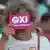 Žena drži listić na kojemu stoji OXI, odnosno Ne