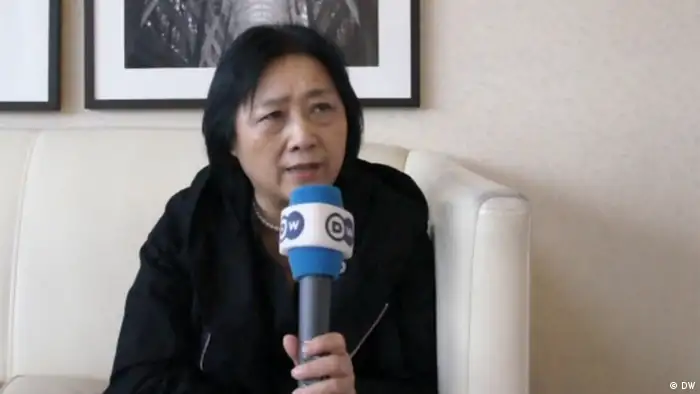 DW-Korrespondentin Gao Yu bei einem Videointerview. Sie hält das DW.-Mikrofon in der linken Hand. (Foto: DW)