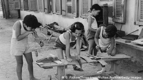 Children use tools to work on wood crafts outside a house (G. Pickow/Three Lions/Hulton Archive/Getty Images)
