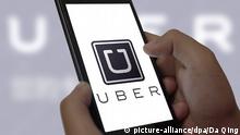 --FILE--A Chinese mobile phone user looks at a logo of taxi-hailing app Uber on his smartphone in Jinan city, east China's Shandong province, 26 June 2015. Uber is planning to set up a Chinese company after police raids at local offices of the controversial ride-booking service provider. China is so different from the rest of the world. We understand how different it is and it should be an independent entity, with separate management and separate headquarters, said Uber co-founder and CEO Travis Kalanick in an interview with Caixin magazine in Beijing. The move would be the first time Uber has set up an independent company for a specific market, rather than simply offices, since its establishment in 2009. The company has expanded into at least 250 cities in 57 countries with its smartphone app that allows people to hail private cars. Of those, the top three cities by number of rides are in China, in Guangzhou, Hangzhou and Chengdu. Police visited two of those offices this year to investigate charges of illegal operation. Kalanick said the new company would be truly Chinese, with Chinese investors and partners who know how to interact with the government and who can help localize Uber for the Chinese market, according to the Caixin report.