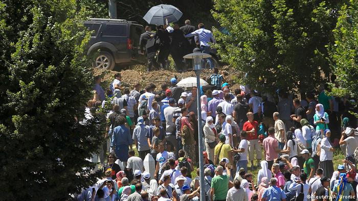 Охрана укрывает сербского премьера от толпы и уводит к машине