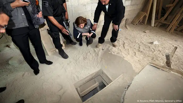 Wachen und Polizisten stehen um ein Loch im Boden einer Zelle. (Foto: Reuters)