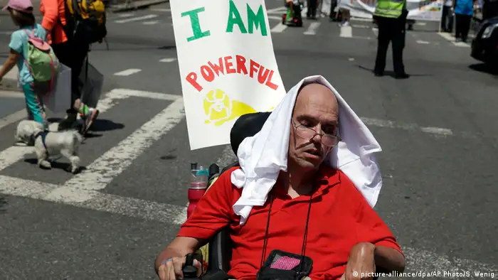 GerardMills sitzt im Rollstuhl und nimmt mit dem Schild Ich bin stark an der Parade teil. (Foto: AP)