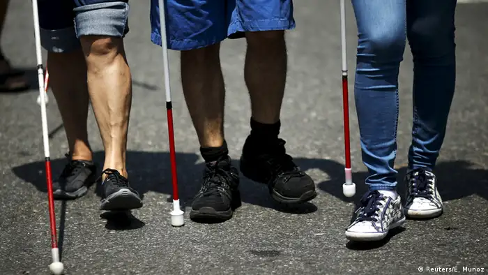 Drei Sehbehinderte mit ihren Blindenstöcken bei der Parade. (Foto: Reuters)