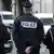 Трое французских полицейских стоят, повернувшись спиной