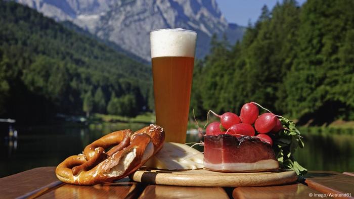 Weizenbier und Brotzeit vor Bergkulisse
