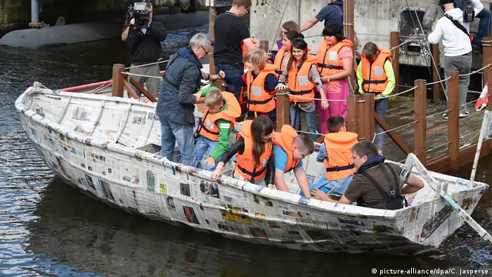 Schüler steigen in das selbstgebaute Papierboot. (Foto: dpa)