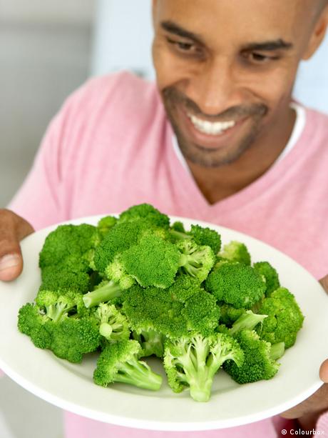 Mann mit Teller Gemüse Brokkoli