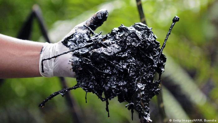 Hand with glove holding oily earth (Photo: RODRIGO BUENDIA/AFP/Getty Images)