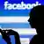 A silhouette of a woman with a floppy ponytail using a smartphone with her forefinger in front of a log-in screen displaying Facebook's blue-and-white logo