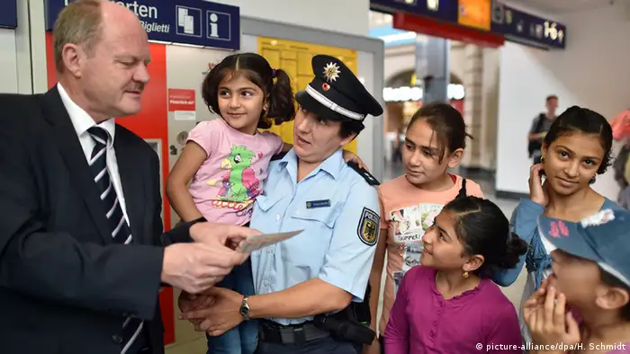 Sachsen-Anhalts Verkehrsminister Thomas Webel erklärt Flüchtlingskindern, wie sie an Fahrkarten kommen (Foto: dpa)